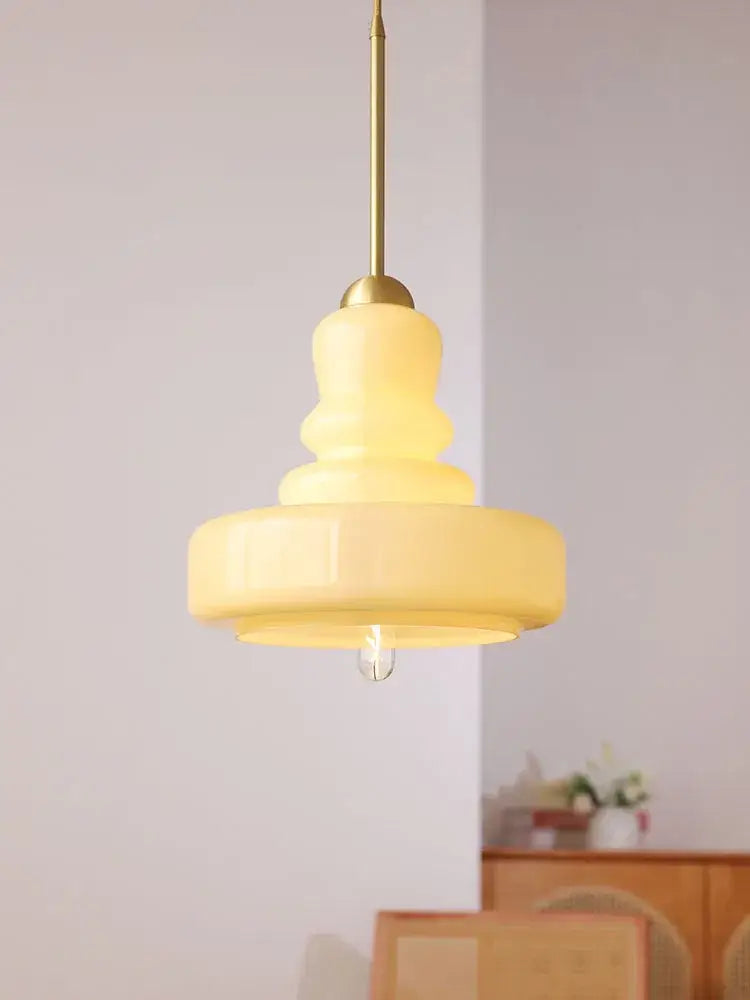 A warm creamy yellow glass pendant light with tiered design and brass rod for kitchen dining colorful gourd pendant lights