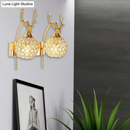 Gold-toned deer wall sconce with crystal dome shade featuring spherical crystals for bedroom wall light decor