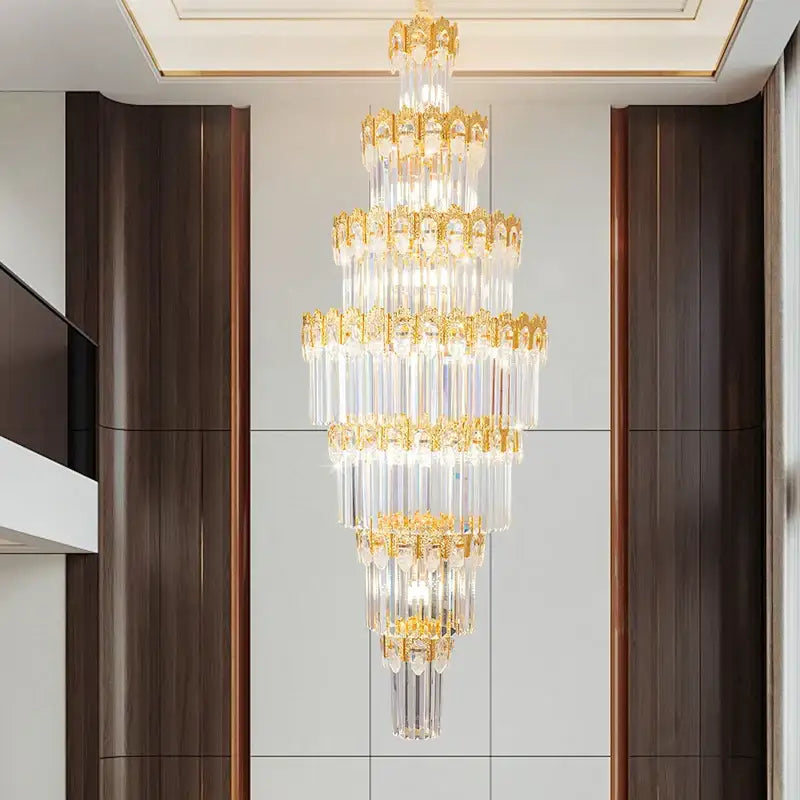 Luxurious gold and clear decorbites crystal staircase chandelier with cascading crystal prisms and ornate metalwork