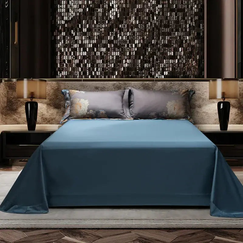 A sleek solid blue satin bedspread with glossy finish drapes over mattress in luxurious gray gold jacquard egyptian cotton bedding set