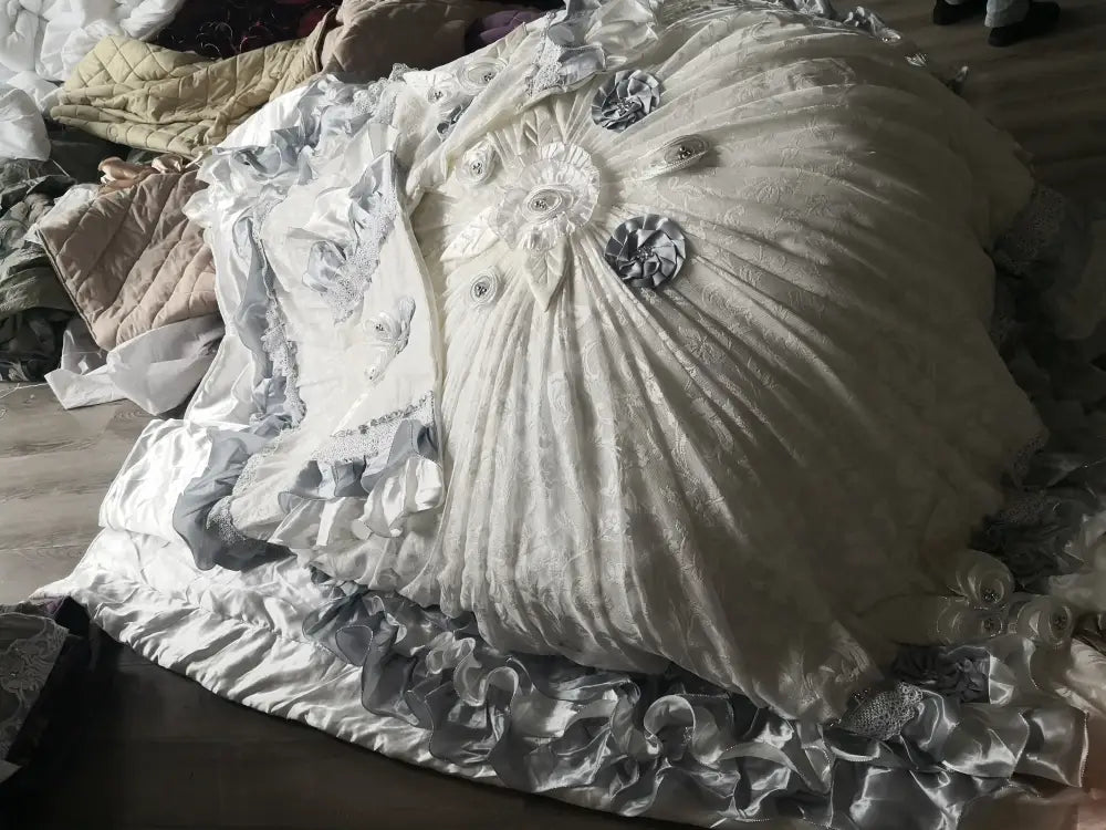A voluminous white satin gown with silver lace and floral appliqués featured alongside decorbites jacquard rose lace bedding set