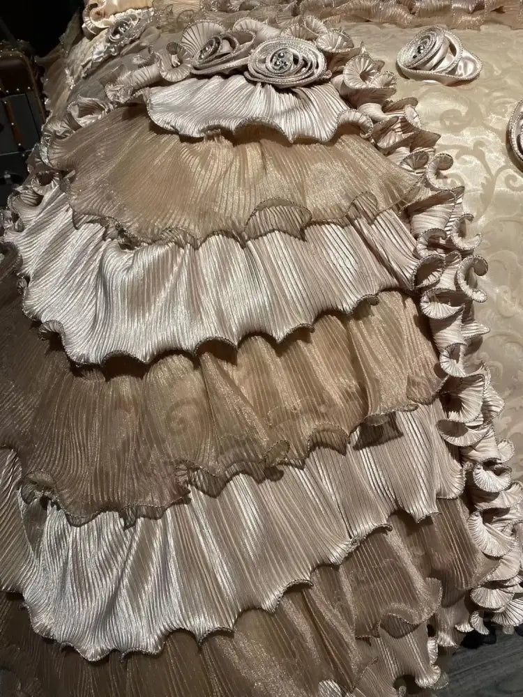 A luxurious multi-tiered gown in shimmering metallic gold with pleated ruffles complements decorbites jacquard rose lace bedding set