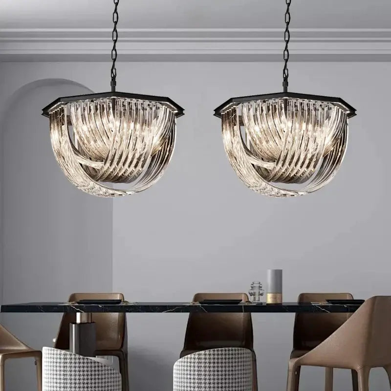 Two elegant black stainless steel glass ribbon chandeliers with twisted shades hang above a dining table
