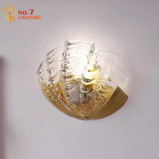 Luxury brass glass shell wall lamp with a translucent textured glass shade and gold-toned metal base for bedroom decorbites brass glass