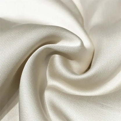 Cream-colored satin fabric with smooth glossy finish and subtle sheen in luxury cream and black ice silk embroidered quilt set