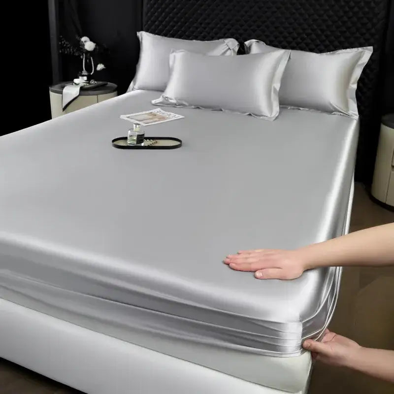 Luxury cream mulberry silk fitted sheet set with smooth silver satin fabric and neatly folded edges for bedroom use