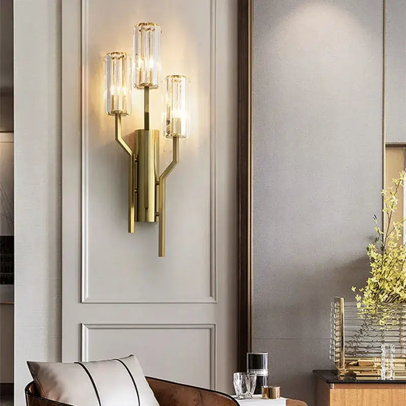 Luxury crystal gold wall lamp with three clear glass cylinders emitting warm light for living room and bedroom decorbites crystal gold