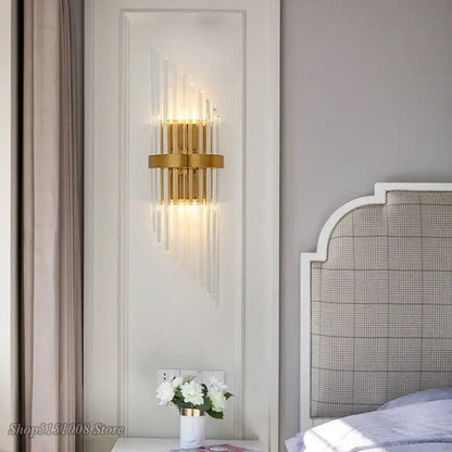 Gold-toned decorbites crystal golden wall lamp with vertical crystal rods and circular base for living room decor