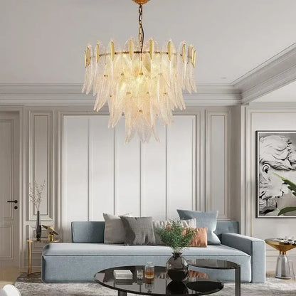 A luxury chandelier featuring decorbites glass leaf translucent pieces and a gold frame for living room lighting