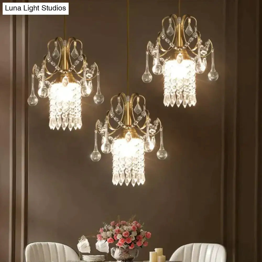 Three elegant brass luxury single head crystal pendant lights with cascading droplets for dining room decorbites
