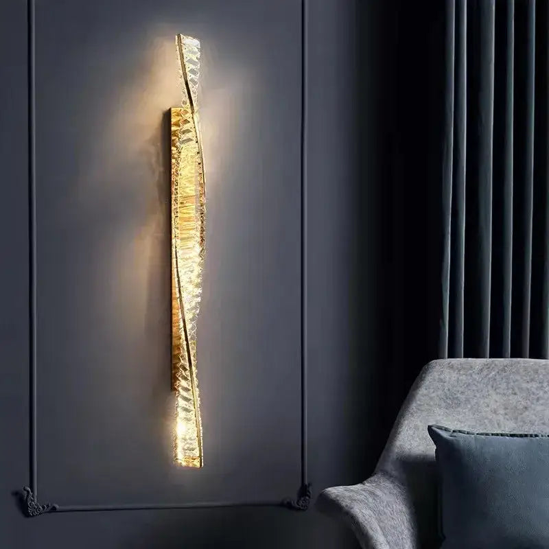 A luxury gold dimmable crystal wall sconce with a textured glass body emitting warm living room light decorbites dimmable crystal