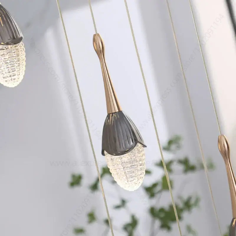 Luxury gold led staircase chandelier with a gold-toned metal stem and dark gray faceted glass shade by decorbites gold led