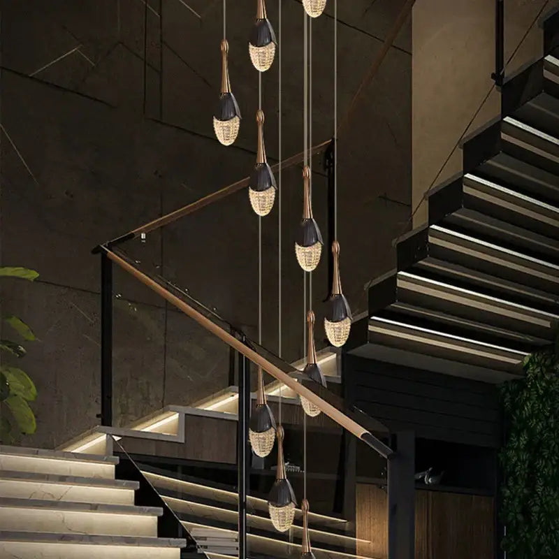 Luxury gold led staircase chandelier with black and gold finishes and crystal teardrop shades by decorbites gold led