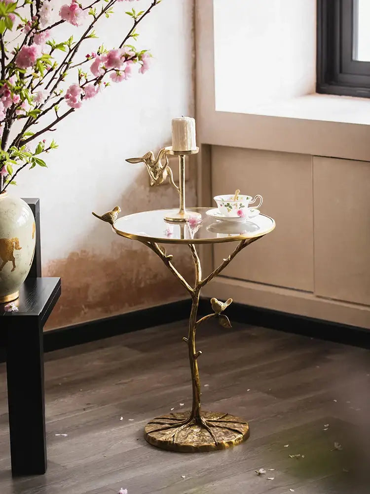 Luxury golden brass bird tree side table with reflective glass top and intricate branch-like base for living room decorbites brass bird decor