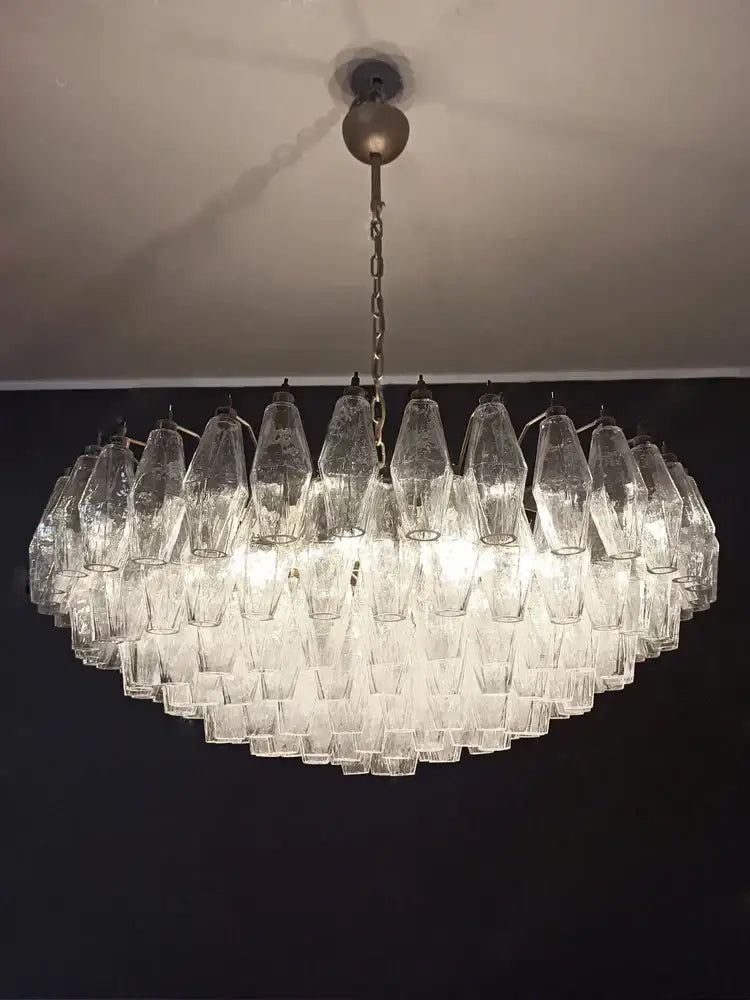 A decorbites gray glass chandelier with smoked crystal tiers and faceted glass shades for dining room lighting