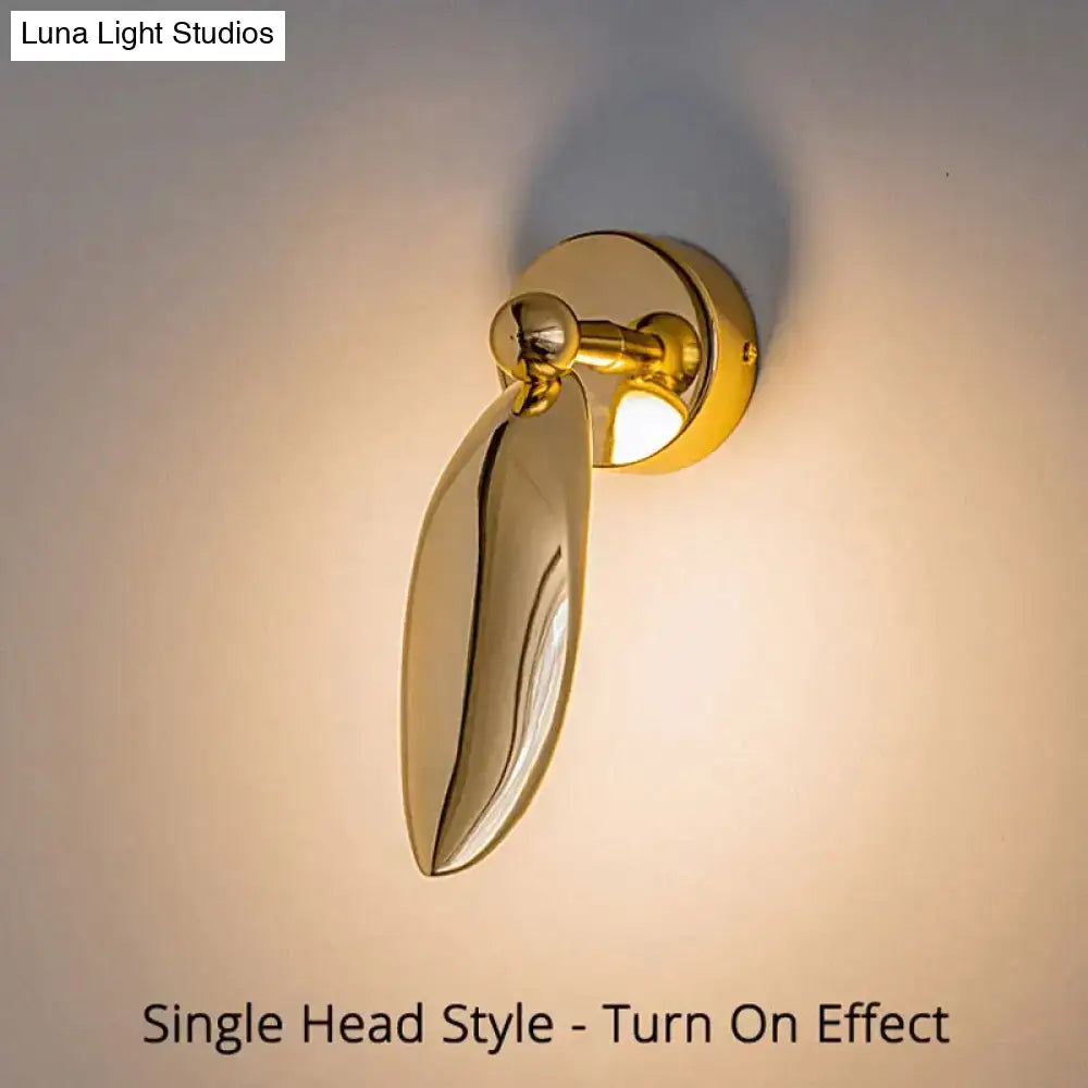 Luxury minimalist creative gold leaf-shaped wall sconce with polished finish and adjustable head for bedroom and living room