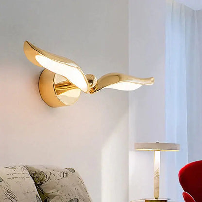 Gold-colored luxury minimalist creative seagull wall lamp with sleek reflective metal wings for bedroom and living room