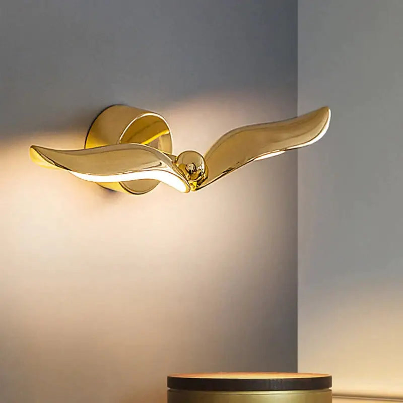 Luxury minimalist creative golden seagull wall lamp with sleek reflective finish and elegant wing design for bedroom
