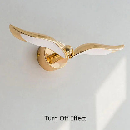Luxury minimalist creative gold wall-mounted seagull lamp with white wing accents for bedroom or living room use