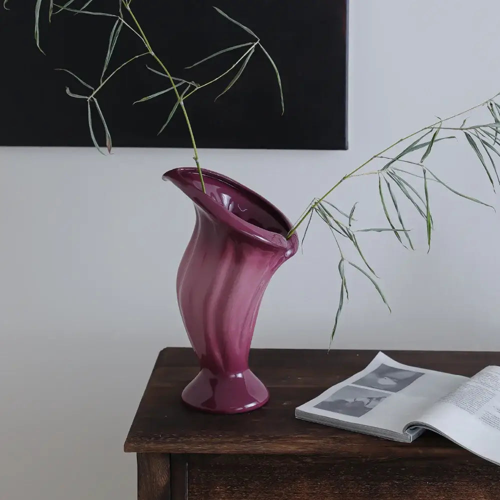 A glossy magenta ceramic vase with flared opening and subtle ridges ideal for decorbites calla lily decor