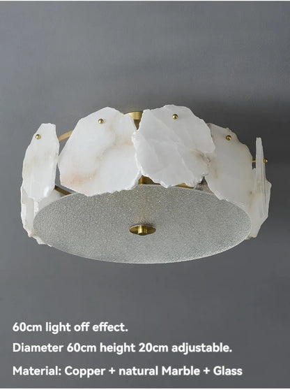 A modern marble led chandelier round pendant light with irregular white marble slices on a brass frame and silver glass base
