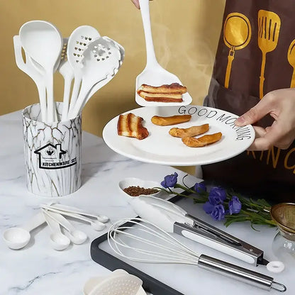 White silicone spatula with flat head lifting bacon from plate in marble pink silicone cooking tool set with container