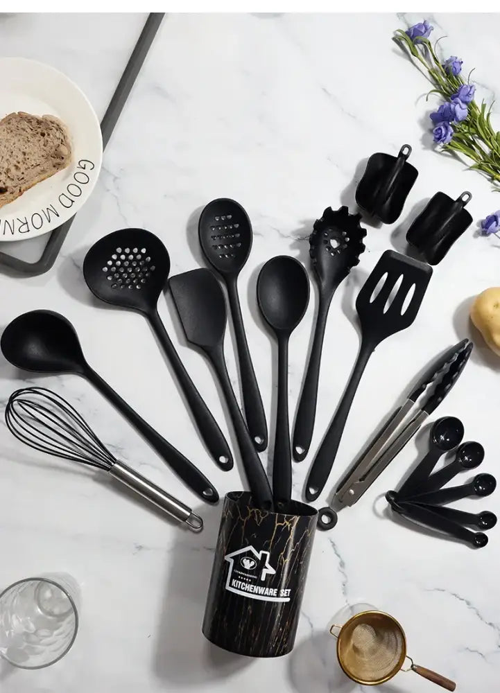 Black silicone cooking tool set in a marbled black and gold cylindrical kitchen storage container for cooking use