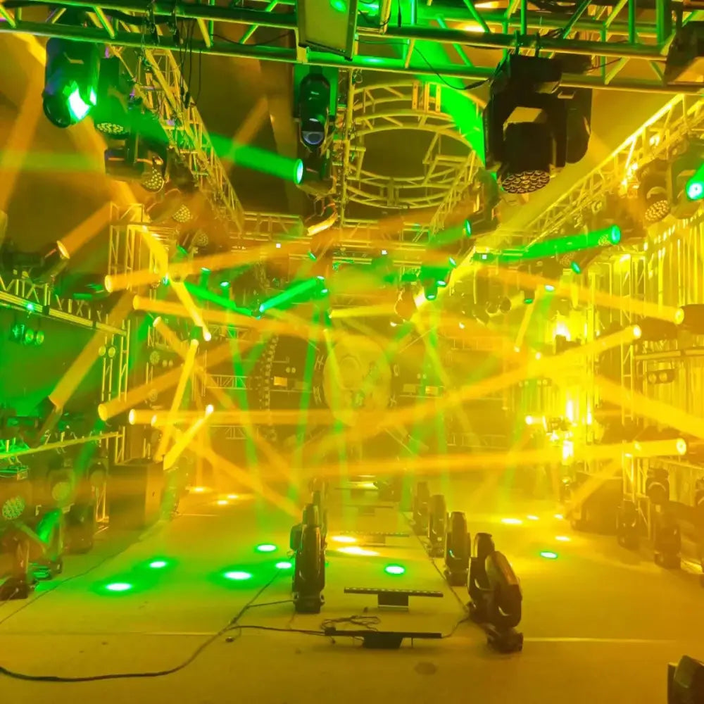 A matte black 150w mini led moving head stage light projecting vibrant green and yellow lasers in a party room setup