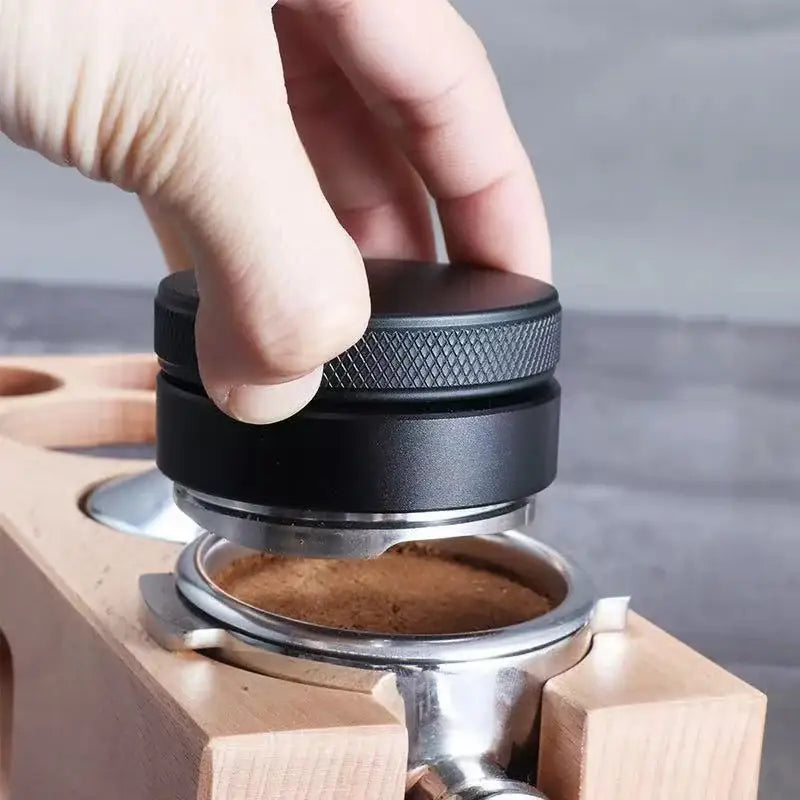 Matte black adjustable palm tamper made of textured metal with a matte finish for kitchen coffee distribution tool