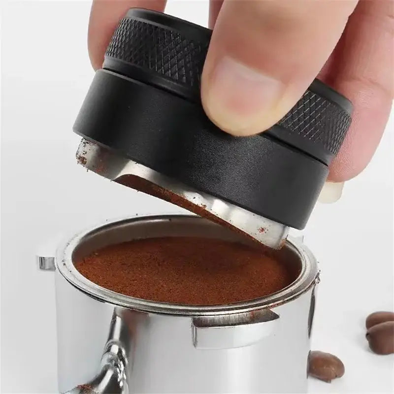 Matte black adjustable palm tamper with textured metal handle and silver base for compressing ground coffee