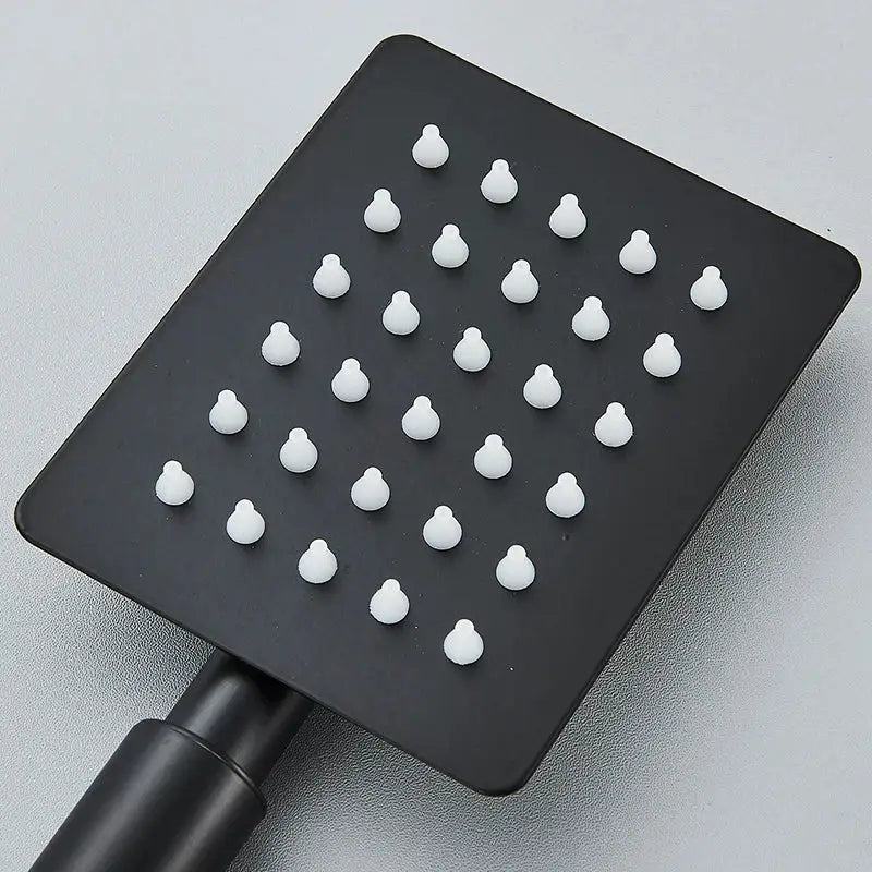 Matte black handheld shower head with white nozzles in grid pattern made of brushed silver stainless steel