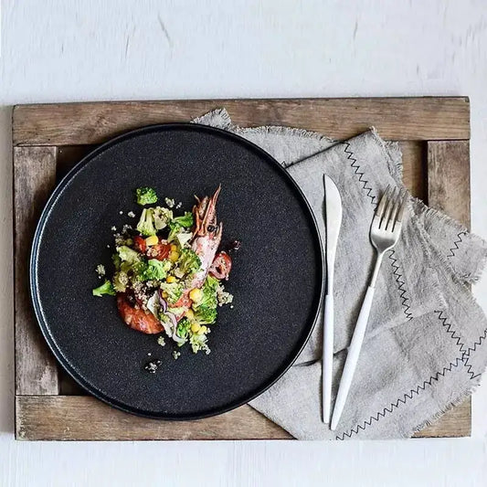 Matte black ceramic dinner plate by decorbites with a matte finish holding a colorful broccoli corn and shrimp salad