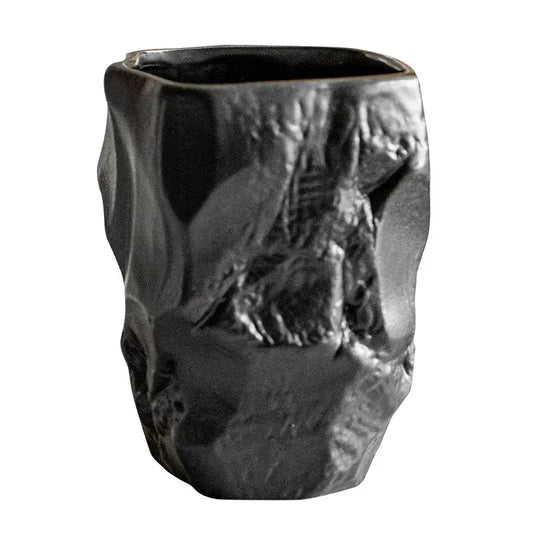 A matte black ceramic mouthwash cup with rugged texture and irregular contours for silicone mold decorbites