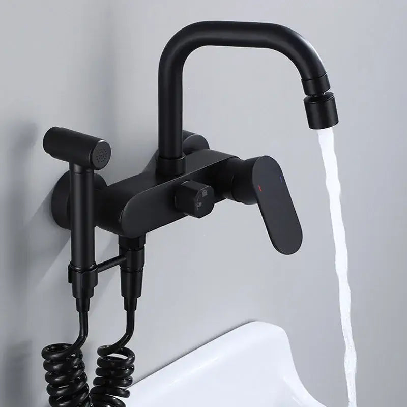 Matte black kitchen mixer tap with a curved spout and integrated handheld showerhead on a coiled hose