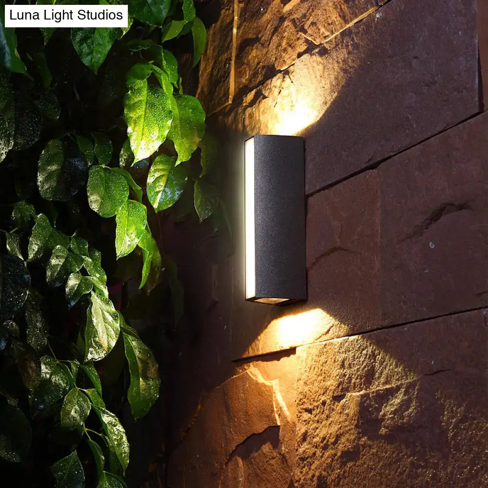 Matte black rectangle outdoor wall light with dual directional led sconce casting warm illumination