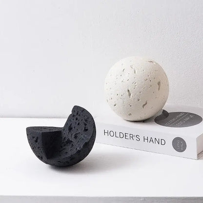 Matte blue geometric spherical home decoration accessory featuring black and white porous volcanic stone spheres, whole and half-cut