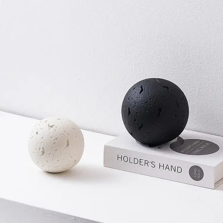 Black textured spherical decoration accessory complementing matte blue geometric home decoration accessory for living room
