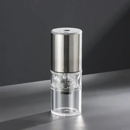 Matte dark teal electric coffee bean grinder with brushed stainless steel top and transparent glass body for kitchen use
