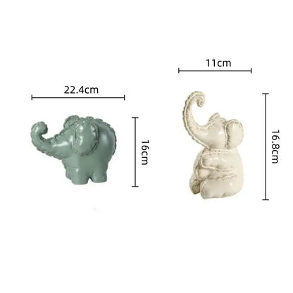 Two ceramic elephant figurines in matte sage green and off-white with decorative detailing for home decor