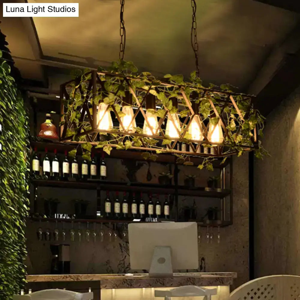Rustic metal island pendant with antique black rectangular frame, six glowing bulbs, and hanging green vines for restaurants