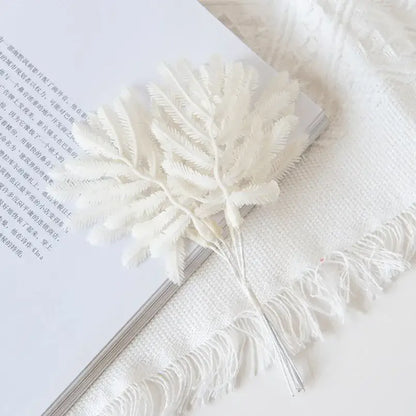 A delicate white artificial fern with feathery fronds in metallic gold and silver palm leaves decorbites gold palm pins