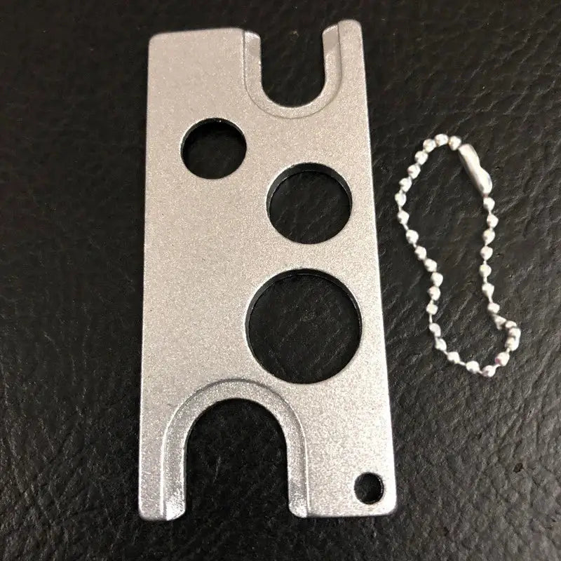 Silver metal multi-tool card holder with three circular cutouts and ball chain for decorbites essential oils opener