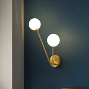 Gold-toned mid century wall light with two opaline glass globes and dual bulb base for living room use