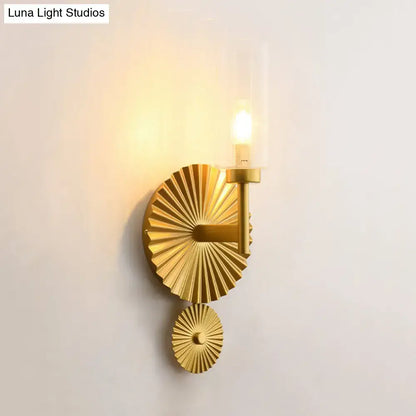 Mid century brass wall sconce with gold-toned scalloped backplate and amber glass wall lamp featuring candle bulb