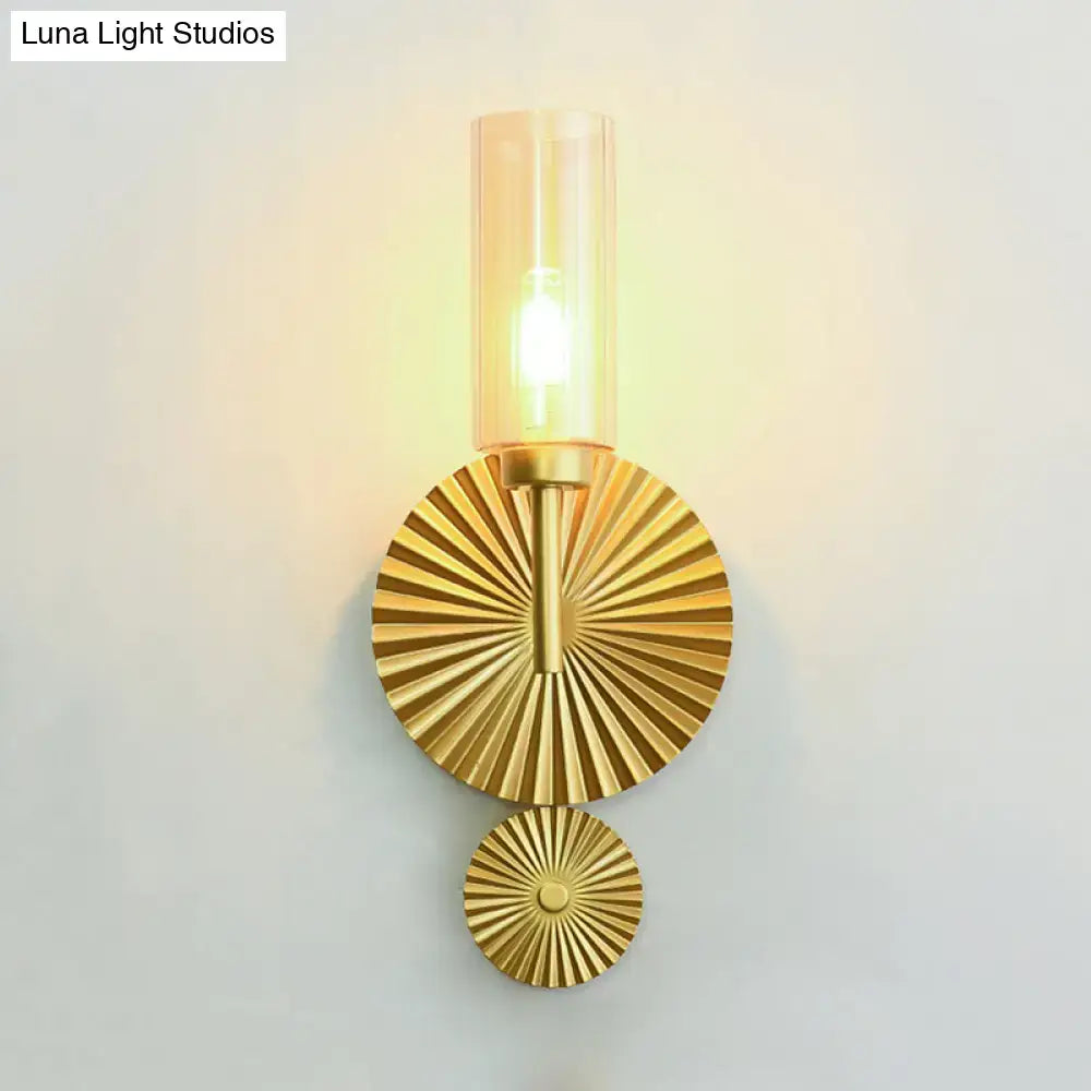 Mid century brass wall sconce with scalloped backplate gold-toned metal and amber cylindrical glass shade for bedroom