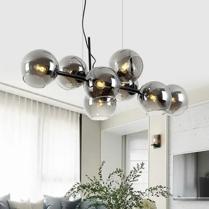 Modern black metal chandelier with smoked glass globes and gold metal accents suitable for 110v-120v led lighting