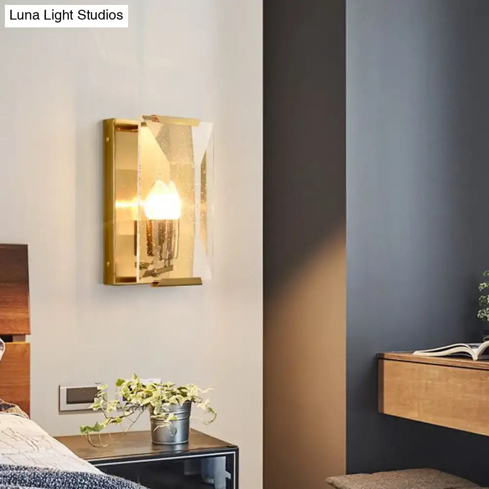 Mid century gold wall sconce with bulb base and clear crystal shield in a rectangular frame for living room lighting