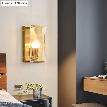 Mid century gold wall sconce with bulb base and clear crystal shield in a rectangular frame for living room lighting