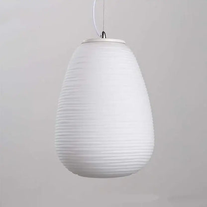 White ribbed pendant light with smooth teardrop glass shade and metallic fixture featuring glass whorls cocoon design