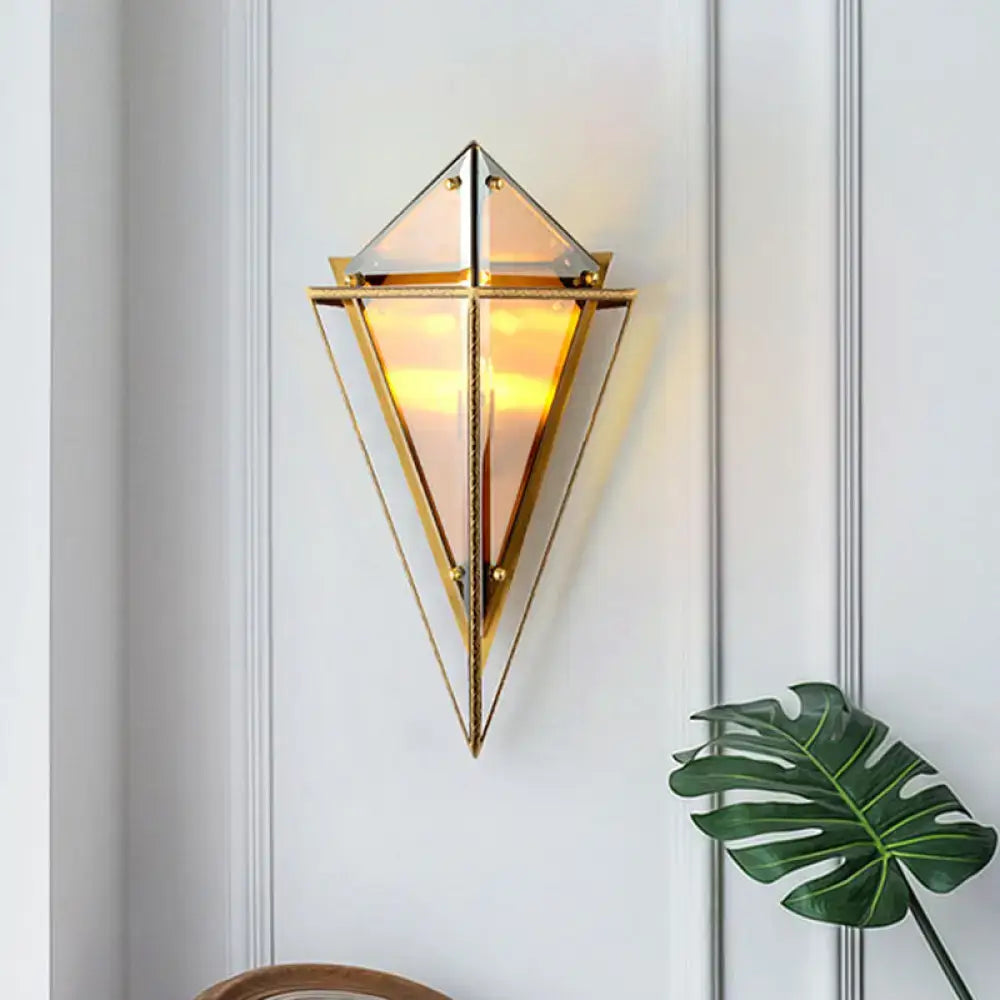 Gold-toned minimalist smoke gray diamond wall light with triangular glass panels and warm glowing light for living room